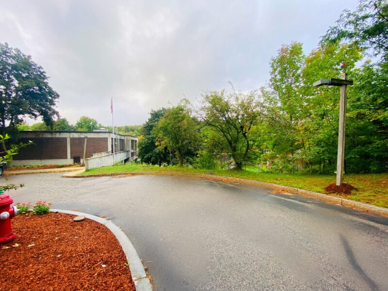 rmsewer Street view of Rumford-Mexico Sewerage District, brick building with red mulch and trees nearby